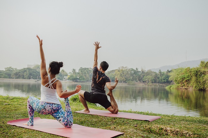 Casal pratica yoga no parque | Tibério Construtora